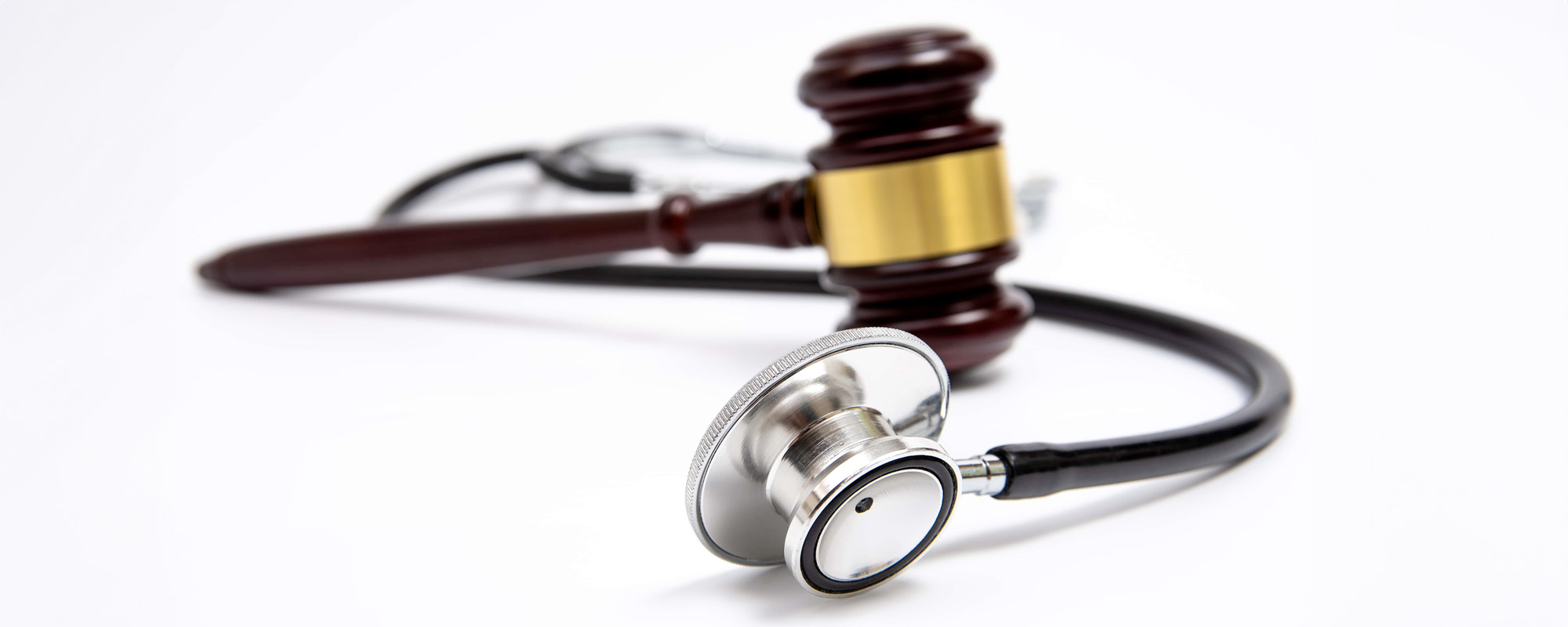 A wooden judge gavel and stethoscope isolated on white background