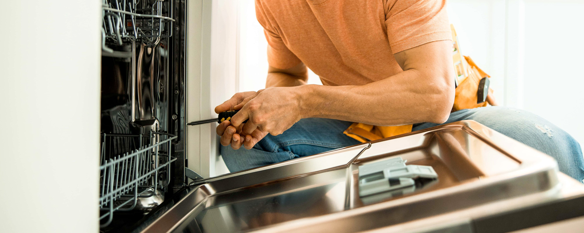Man is repairing appliances in the kitchen