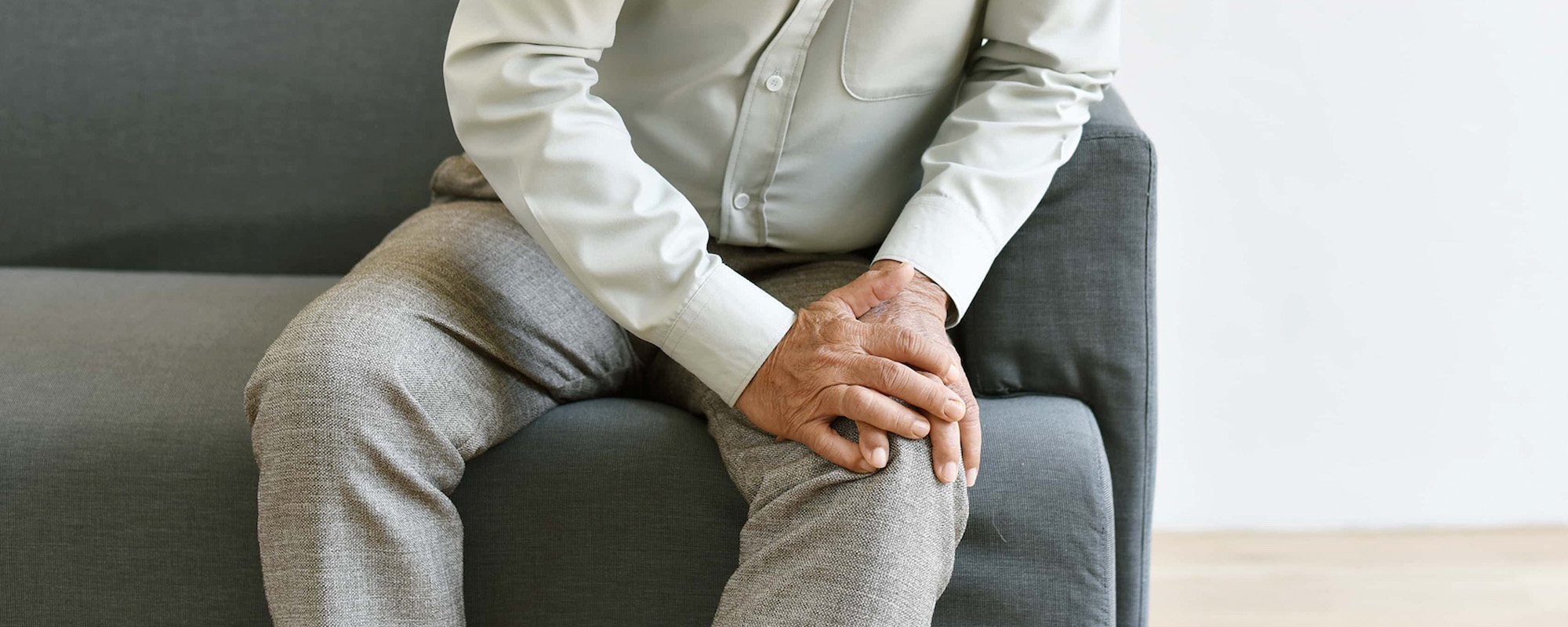 arthritis joint pain problem in old man elderly asian man with hand on knee gesture