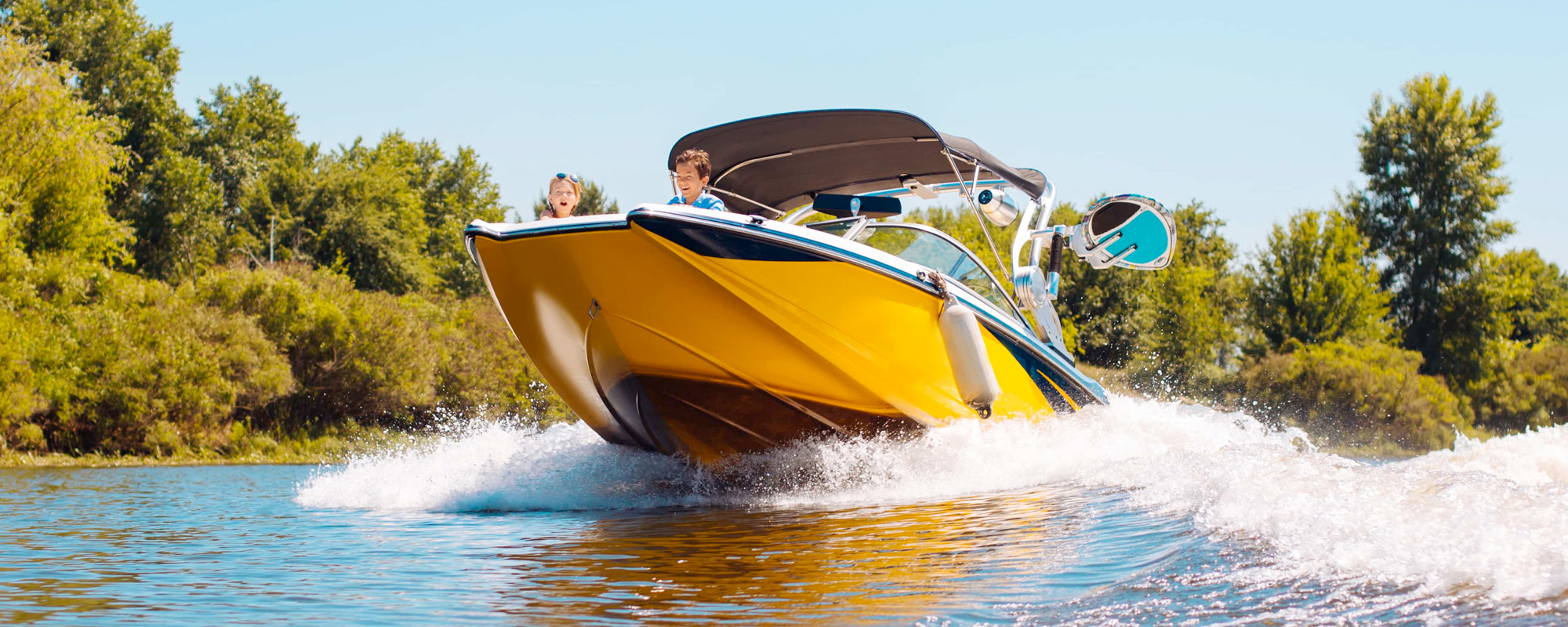 happy family sailing a motorboat down the river